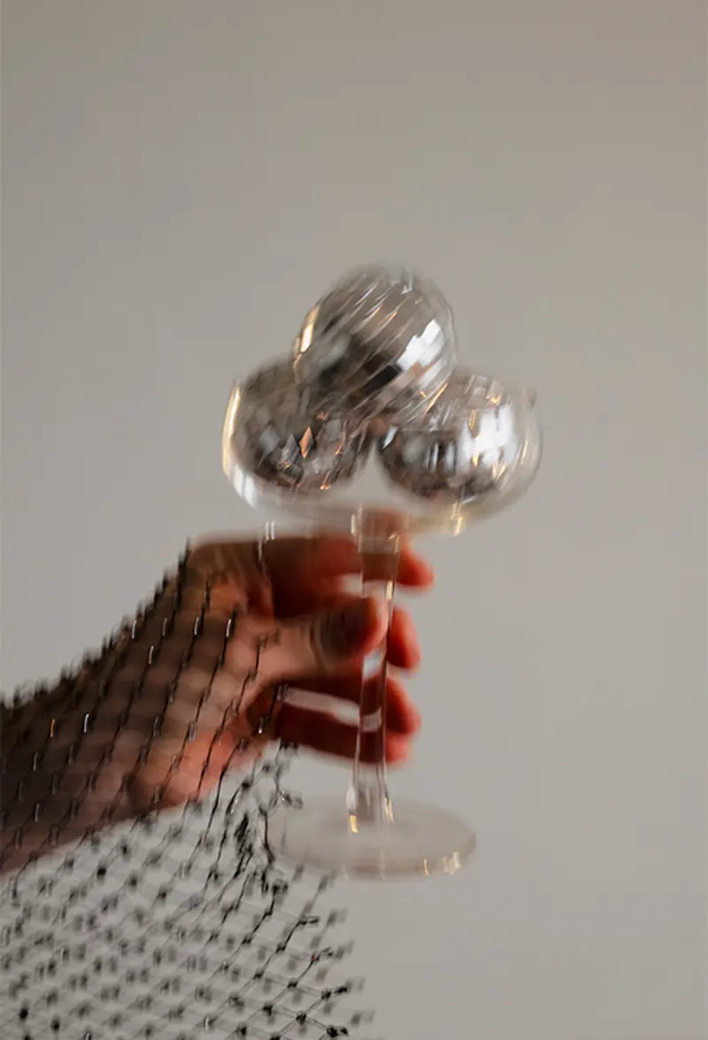 Hand holding glas with discoballs.